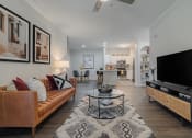 Thumbnail 6 of 54 - a living room with a tv and a kitchen in the background