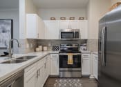 Thumbnail 2 of 54 - a kitchen with white cabinets and stainless steel appliances