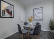 Thumbnail 4 of 54 - a dining room with a round table with four chairs and a vase with yellow flowers on