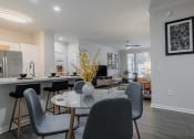 Thumbnail 5 of 54 - a dining area with a table and chairs and a kitchen in the background