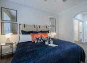 Thumbnail 12 of 54 - a bedroom with a blue bedspread and orange pillows