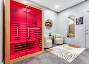 Thumbnail 29 of 50 - A red room with a chair and a wicker basket on the wall.