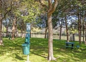 Thumbnail 15 of 22 - a park with a trash can and a picnic table
