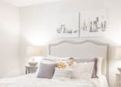 Thumbnail 8 of 34 - a white bedroom with a bed and pillows and a painting on the wall