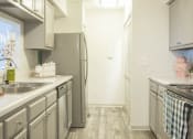Thumbnail 6 of 34 - a kitchen with stainless steel appliances and white counter tops