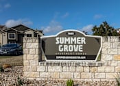 Thumbnail 10 of 23 - A sign for Summer Grove Apartment Homes is displayed in front of a building.