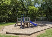 Thumbnail 20 of 20 - A playground with a blue slide and a wooden structure.