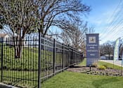 Thumbnail 19 of 19 - A sign for Covington Apartments stands in front of a black fence.