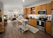 Thumbnail 2 of 21 - A modern kitchen with wooden cabinets and a white island.