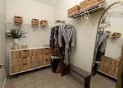 Thumbnail 5 of 21 - A room with a white wall and a wooden cabinet with drawers.