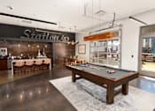 Thumbnail 8 of 21 - A room with a pool table and a bar area.