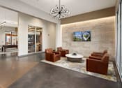Thumbnail 7 of 21 - A modern living room with a stone wall and a flat screen TV.