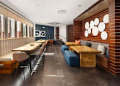 Thumbnail 12 of 21 - A long wooden table with chairs and a bench is in a room with a brick wall.