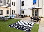 Thumbnail 18 of 21 - A checkerboard is on the lawn in front of a building.