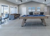 Thumbnail 40 of 62 - A pool table is in the middle of a room with a couch and a chair.