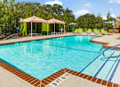 Thumbnail 13 of 17 - A swimming pool with a pavilion and lounge chairs.
