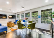Thumbnail 3 of 17 - A modern living room with a blue sofa, green chairs, and a wooden coffee table.