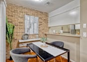 Thumbnail 8 of 17 - Small dining area outside a kitchen bartop with midcentury modern brick walls and brown concrete flooring