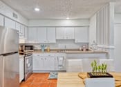 Thumbnail 4 of 17 - Kitchen with glossy brown concrete floors, white cabinetry, and stainless steel appliances