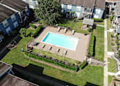 Thumbnail 22 of 29 - A swimming pool surrounded by a grassy area and a few trees.