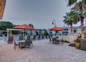 Thumbnail 5 of 26 - A patio with chairs and umbrellas is set up for dining.