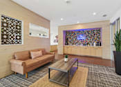 Thumbnail 19 of 19 - A living room with a brown couch and a coffee table.
