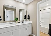 Thumbnail 30 of 37 - A bathroom with two sinks and a large mirror.