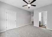 Thumbnail 38 of 45 - A room with a ceiling fan and carpeted floor.