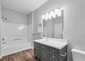 Thumbnail 40 of 45 - A bathroom with a white sink and a white bathtub.