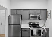Thumbnail 20 of 45 - A kitchen with a stove and oven with a towel on it.