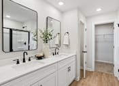 Thumbnail 35 of 37 - A white bathroom with a large mirror above the sink.