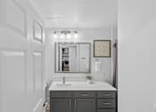Thumbnail 28 of 45 - A bathroom with a sink, mirror, and cabinets.