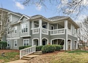 Thumbnail 36 of 45 - A grey two-story house with a white porch.