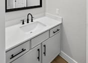 Thumbnail 35 of 45 - A bathroom with a sink and mirror.