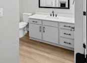 Thumbnail 42 of 45 - A white bathroom with a toilet, sink, and mirror.
