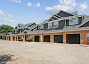 Thumbnail 28 of 38 - A row of houses with black garage doors.