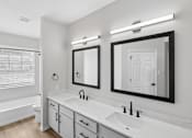 Thumbnail 41 of 45 - A white bathroom with a sink, mirror, and bathtub.