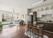Thumbnail 9 of 19 - an open living room with a kitchen with a bar and stools