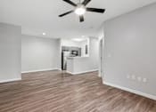 Thumbnail 4 of 45 - A room with a ceiling fan and wooden flooring.