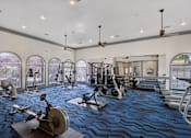 Thumbnail 36 of 38 - A spacious gym with a variety of equipment and a large mirror on the wall.