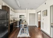 Thumbnail 11 of 19 - a kitchen with black appliances and a wooden table