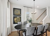 Thumbnail 18 of 37 - A dining room with a black table and chairs.