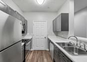 Thumbnail 2 of 45 - A kitchen with a white door in the middle.