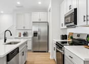 Thumbnail 11 of 37 - A modern kitchen with stainless steel appliances and white cabinetry.