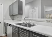 Thumbnail 3 of 45 - A kitchen with a white counter top and grey cabinets.