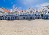 Thumbnail 28 of 29 - A large white building with red roofs and balconies.
