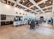 Thumbnail 24 of 32 - A spacious kitchen and dining area with wooden ceiling beams and tiled flooring.