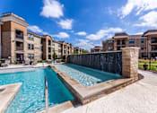 Thumbnail 17 of 32 - A swimming pool in front of apartment buildings.