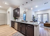 Thumbnail 6 of 32 - A kitchen with dark brown cabinets and a granite countertop.
