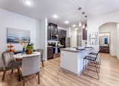 Thumbnail 5 of 32 - A modern kitchen with a dining table and chairs.